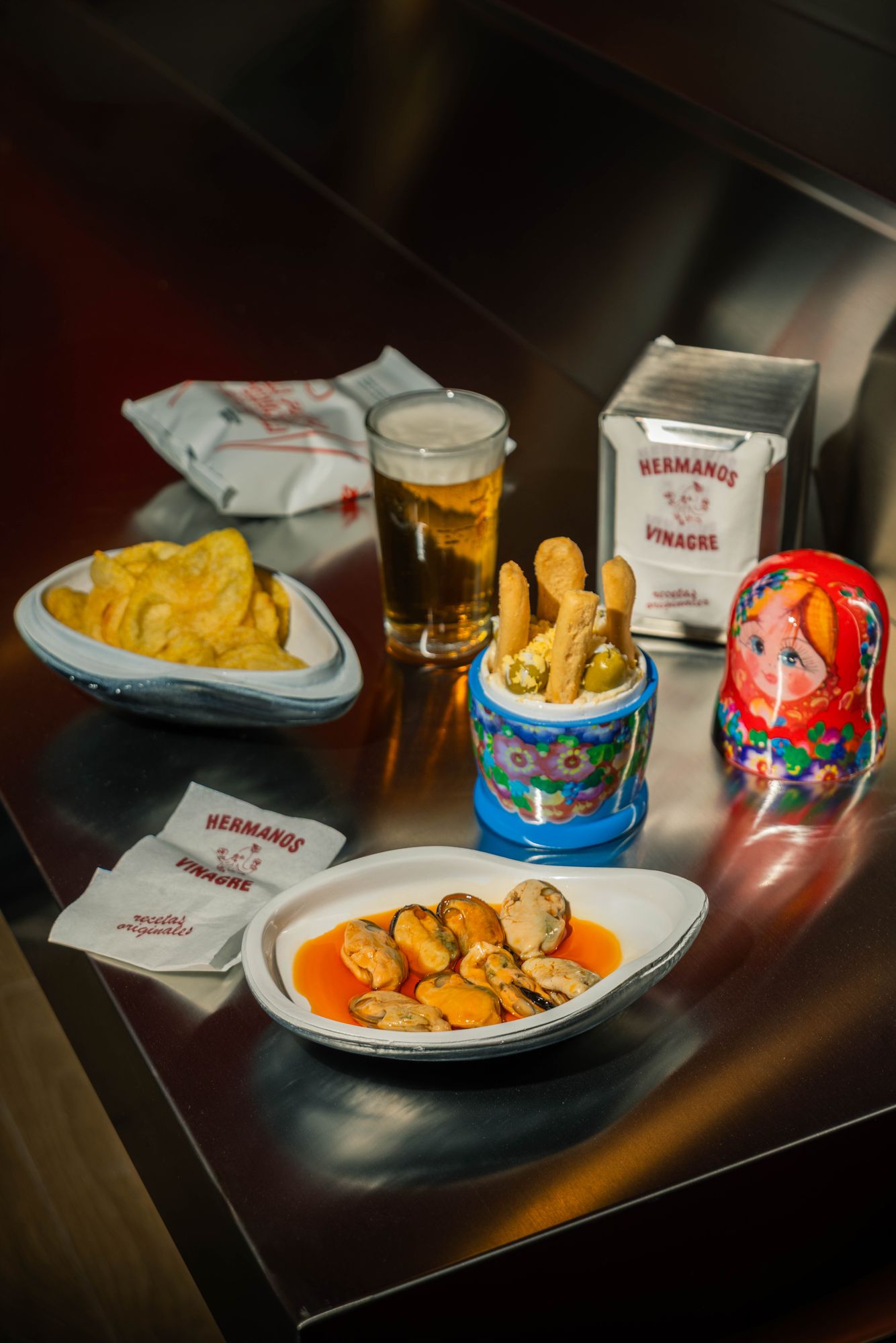 A freshly pulled caña with mussels in escabeche and Russian salad in a matryoshka
