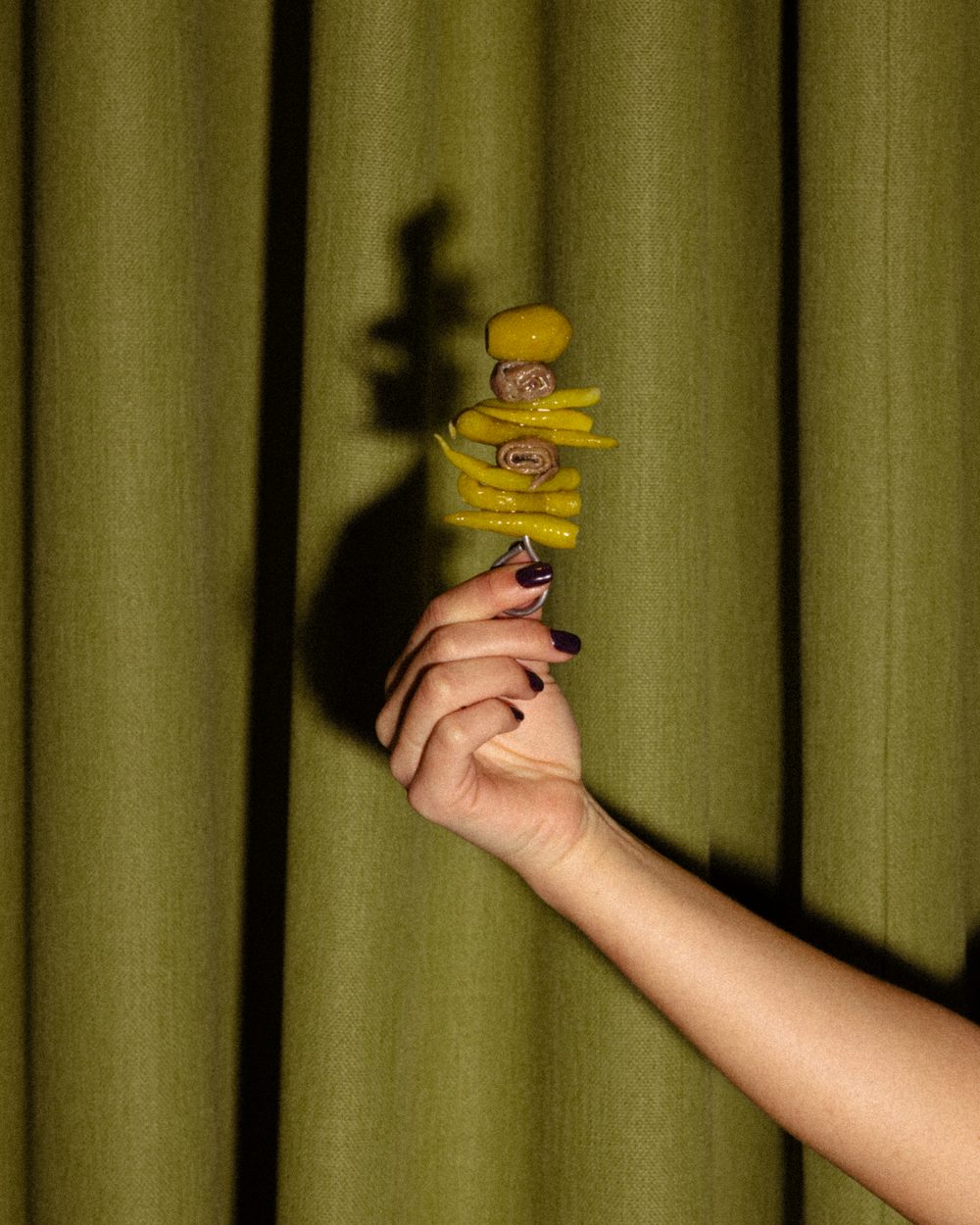 The world's most expensive gilda, held up in front of a green curtain