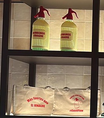 Hermanos Vinagre soda siphons and tote bags on the shelf in Mercado Madriles