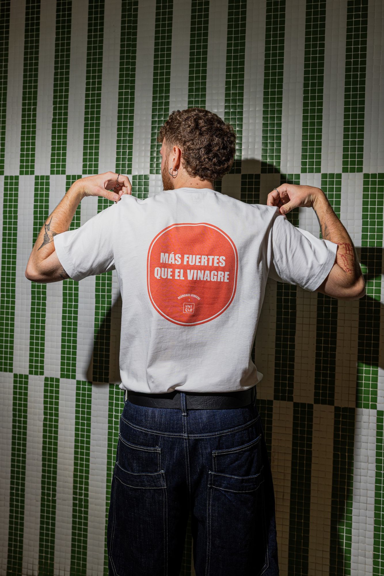 A guy seen from behind wearing the “Más fuertes que el vinagre” T-shirt at a Hermanos Vinagre bar